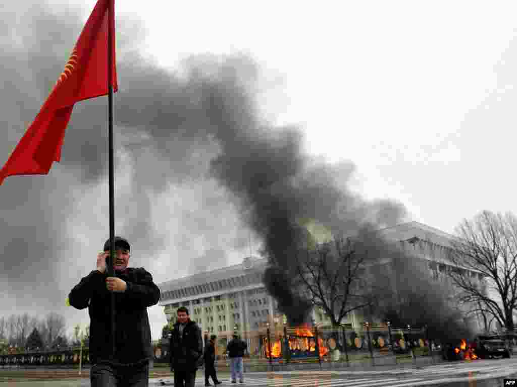 Ақ үй жанында наразылық шарасына қатысушы қырғыз туын ұстап тұр. Біішкек, 7 сәуір, 2010 жыл.