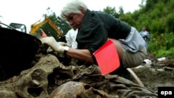 Forensic experts examine a mass grave in Kamenica, Bosnia-Herzegovina, in 2002, near the site of the 1995 Srebrenica massacre.