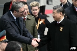 Președintele sârb Alexandr Vucic și președintele chinez Xi Jinping își strâng mâna în timpul unei ceremonii de depunere de flori la Mormântul Soldatului Necunoscut de lângă zidul Kremlinului din centrul Moscovei, pe 9 mai 2025.