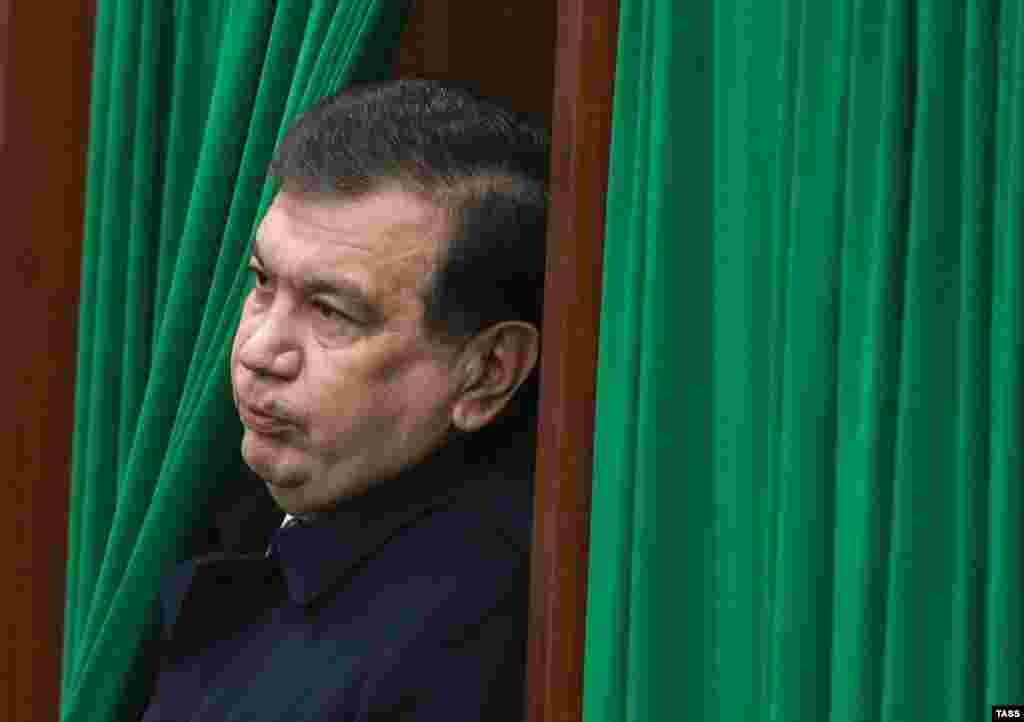 Назначение Мирзияева исполняющим обязанности президента состоялось в обход порядка, определенного в Конституции Узбекистана, по которому пост и. о. президента должен был занять спикер верхней палаты парламента. На фото: Мирзияев выходит из кабинки для голосования на участке в Ташкенте.
